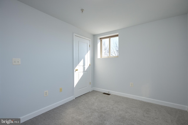 unfurnished room with baseboards, visible vents, and light colored carpet