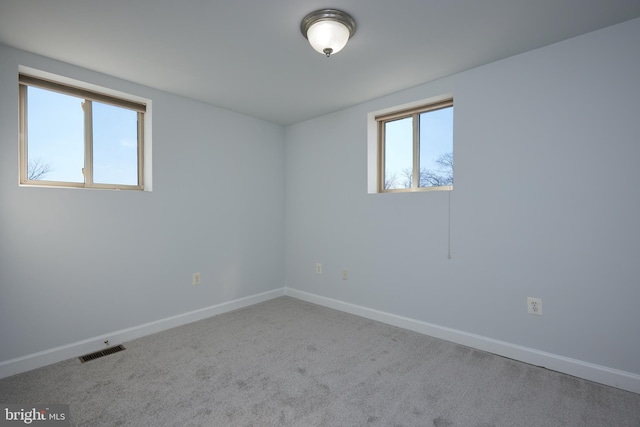 carpeted empty room featuring visible vents and baseboards