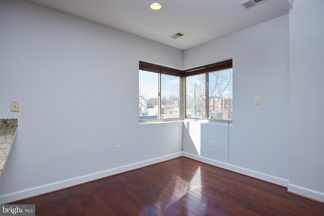 empty room featuring recessed lighting, wood-type flooring, visible vents, and baseboards