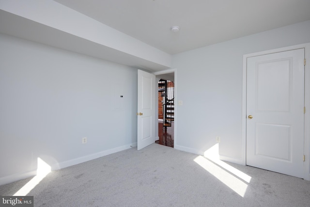 unfurnished bedroom featuring light carpet and baseboards