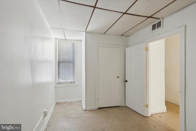 unfurnished bedroom featuring a drop ceiling