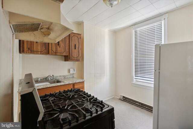 2048 S Croskey St, Philadelphia, PA 19145 - kitchen featuring freestanding refrigerator, a sink, gas range oven, brown cabinets, and light countertops
