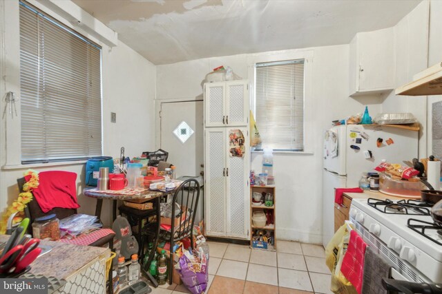 2048 S Croskey St, Philadelphia, PA 19145 - kitchen featuring white gas stove, light tile patterned floors, and white cabinetry