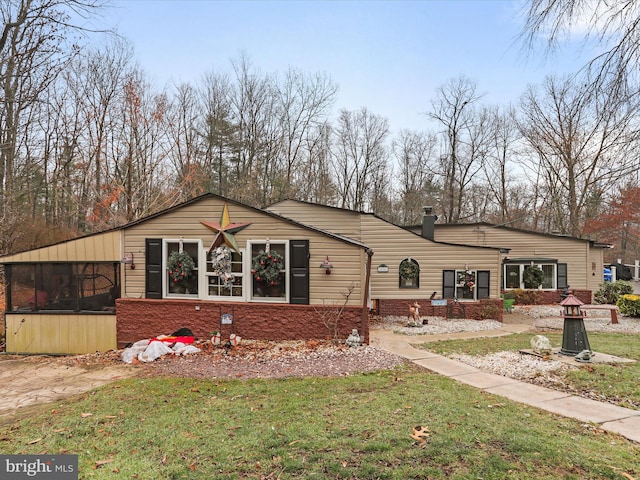 view of front of home featuring a sunroom and a front lawn