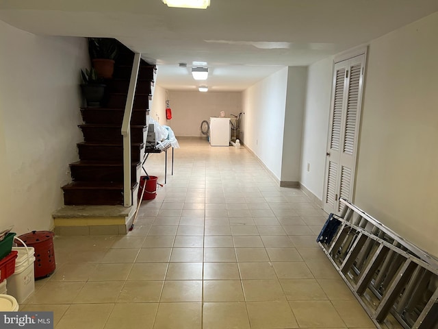 corridor with light tile patterned floors and washer / clothes dryer