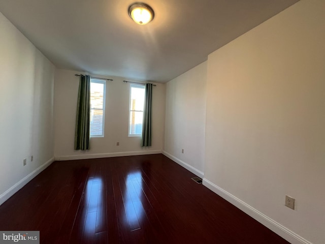 spare room featuring dark wood-type flooring