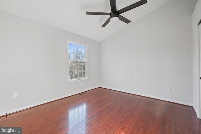 empty room featuring dark hardwood / wood-style flooring, vaulted ceiling, and ceiling fan