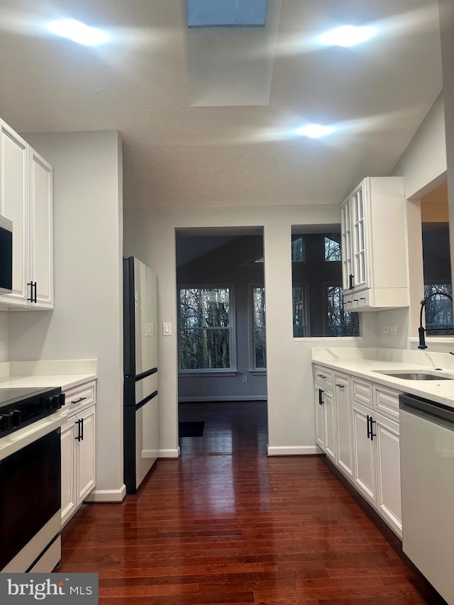 kitchen with stainless steel appliances, white cabinetry, dark hardwood / wood-style floors, and sink