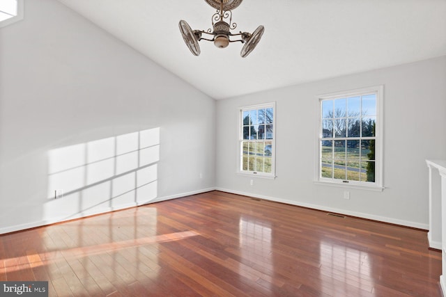 spare room with dark hardwood / wood-style floors, ceiling fan, and vaulted ceiling