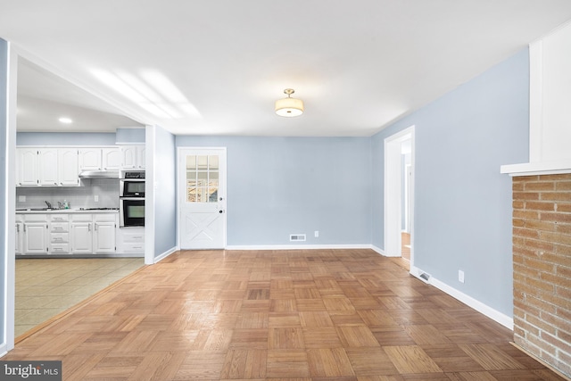 unfurnished living room with light parquet flooring