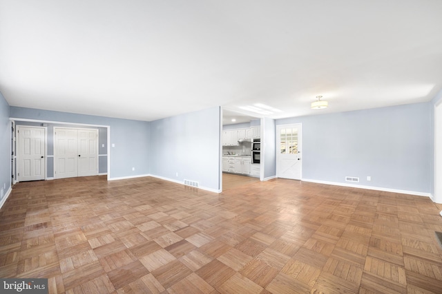 unfurnished living room with light parquet floors