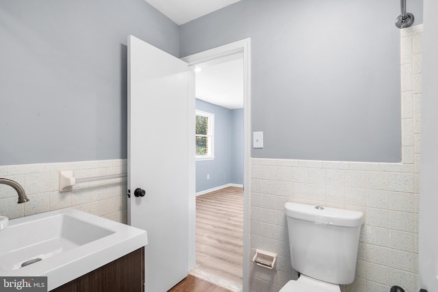 bathroom featuring hardwood / wood-style floors, vanity, toilet, and tile walls