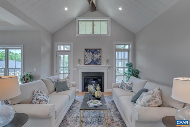 living room with beam ceiling, high vaulted ceiling, a healthy amount of sunlight, and hardwood / wood-style flooring