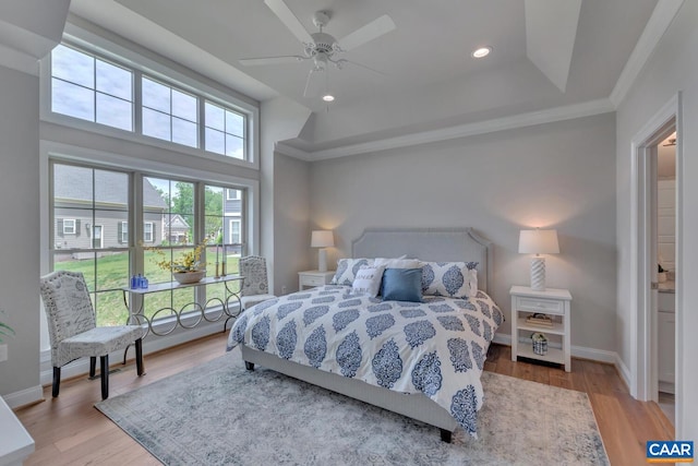 bedroom with ceiling fan, light hardwood / wood-style flooring, crown molding, and a high ceiling