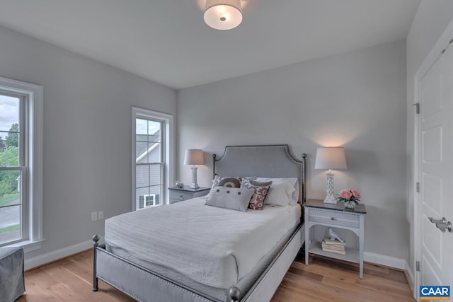 bedroom featuring light hardwood / wood-style flooring and multiple windows