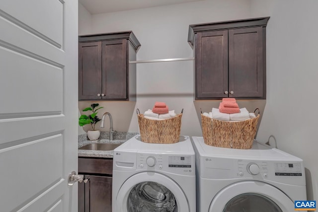 laundry area featuring washing machine and clothes dryer, sink, and cabinets