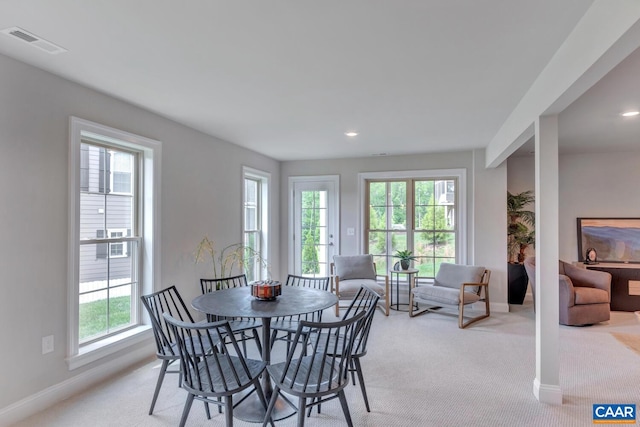 dining space with light carpet and a wealth of natural light