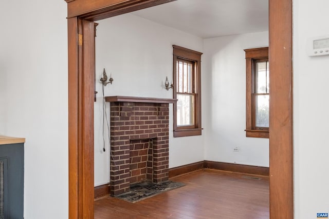 unfurnished living room featuring dark hardwood / wood-style flooring and a fireplace