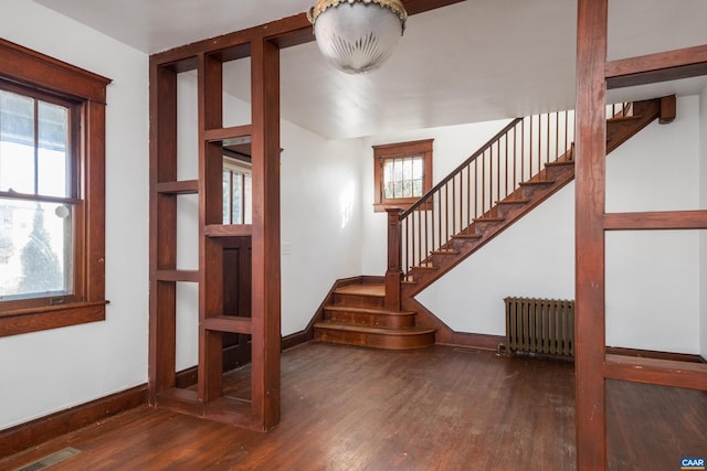 staircase featuring radiator and hardwood / wood-style floors