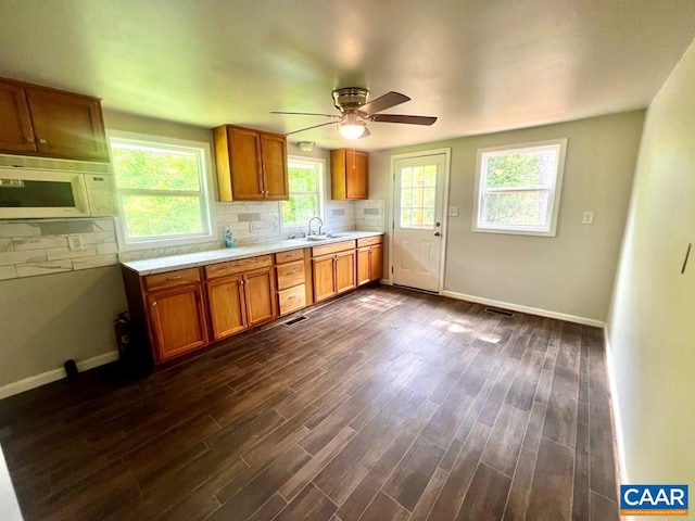 kitchen with backsplash, ceiling fan, sink, and dark hardwood / wood-style floors