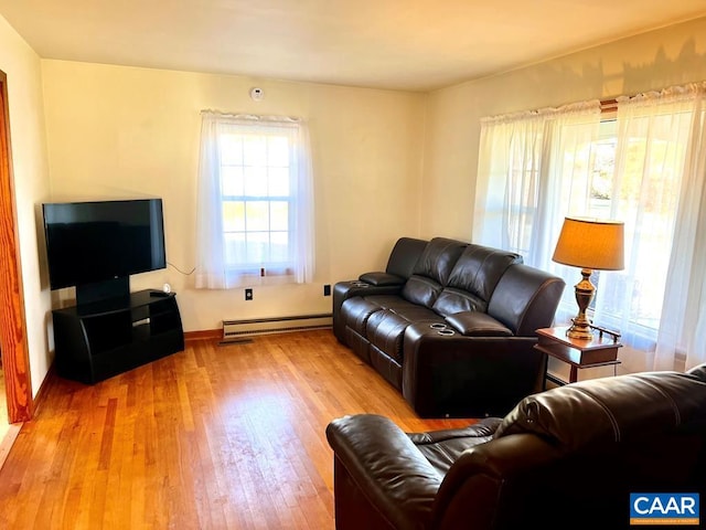 living room featuring a baseboard heating unit and hardwood / wood-style flooring