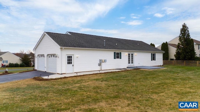 rear view of property with a yard and a garage