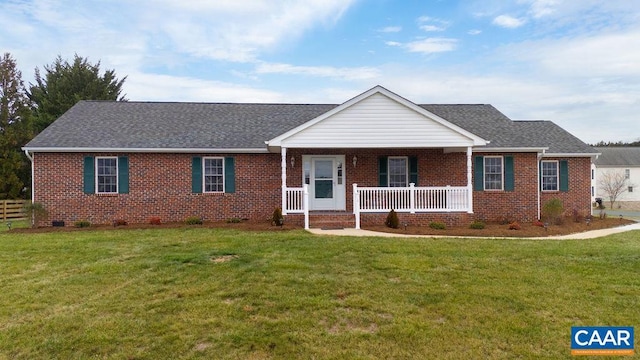 ranch-style home featuring covered porch and a front yard