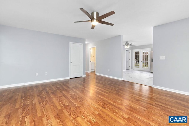 unfurnished room with hardwood / wood-style floors, ceiling fan, and french doors