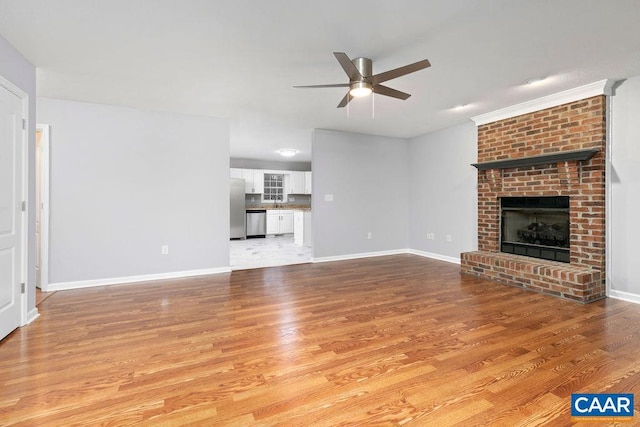 unfurnished living room featuring ceiling fan, light hardwood / wood-style floors, and a brick fireplace