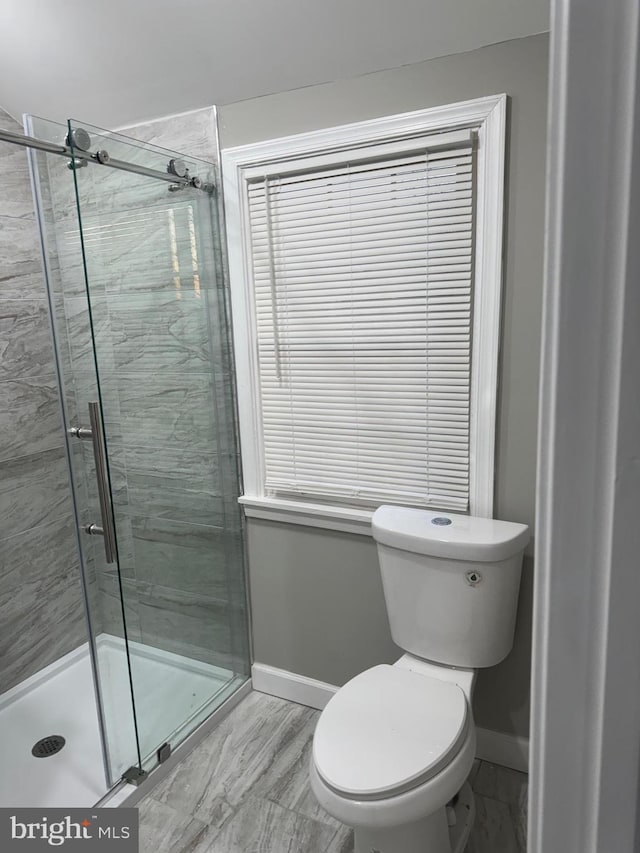 bathroom with toilet and a shower with shower door