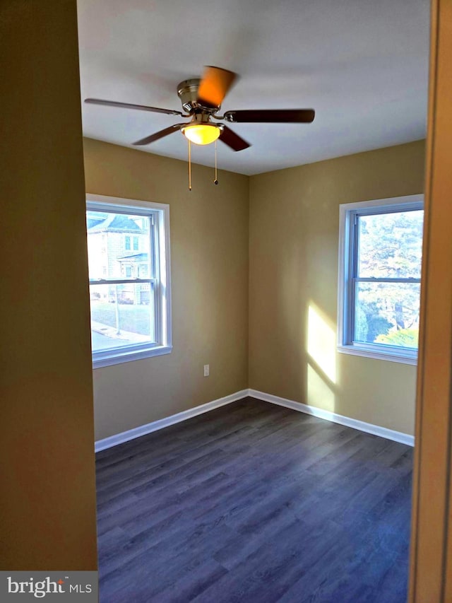 spare room with dark hardwood / wood-style floors, a healthy amount of sunlight, and ceiling fan