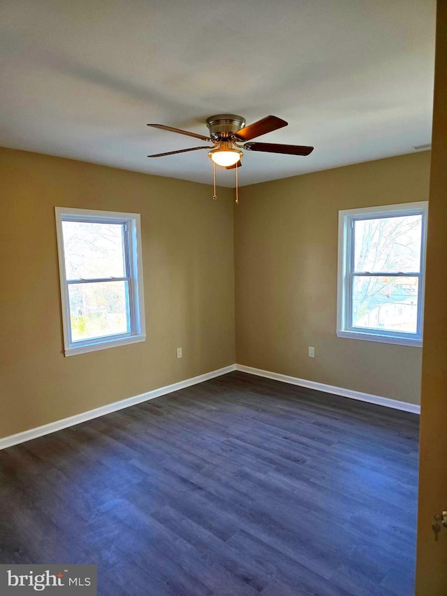 spare room featuring ceiling fan and dark wood-type flooring