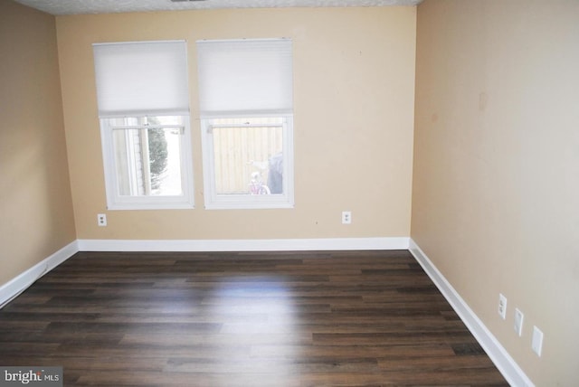 unfurnished room featuring a textured ceiling and dark hardwood / wood-style floors