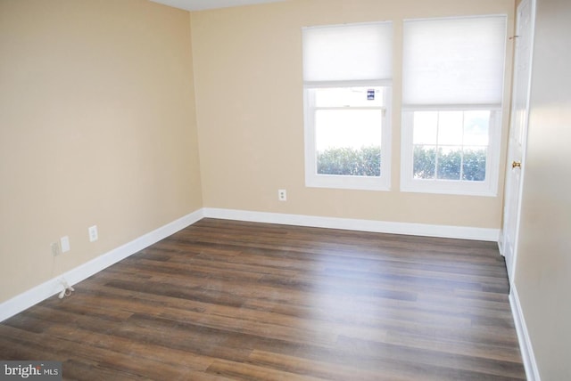 empty room with dark hardwood / wood-style flooring