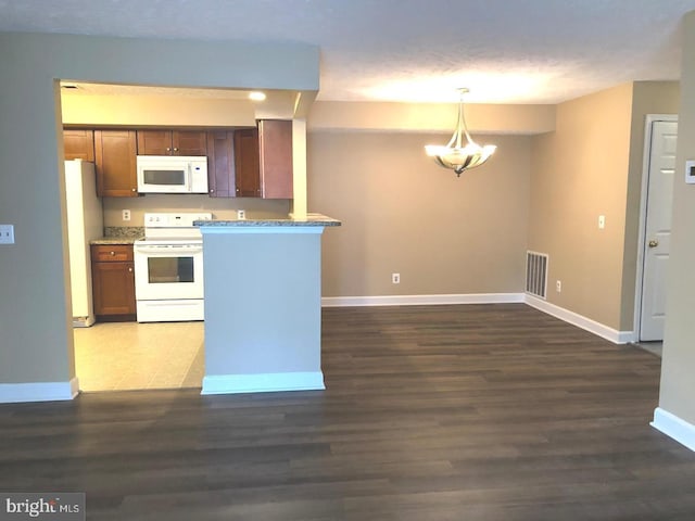 kitchen featuring kitchen peninsula, dark hardwood / wood-style flooring, white appliances, pendant lighting, and a notable chandelier