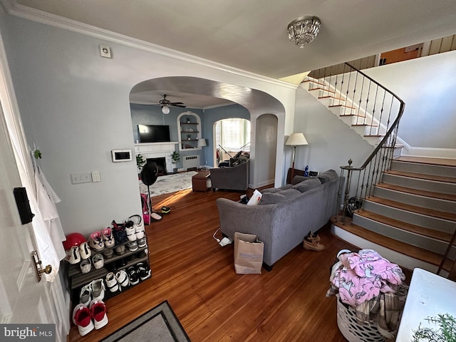 living room featuring ceiling fan, dark hardwood / wood-style flooring, and ornamental molding