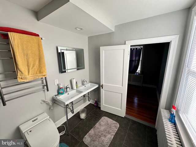 bathroom featuring hardwood / wood-style floors, double sink, toilet, and a healthy amount of sunlight