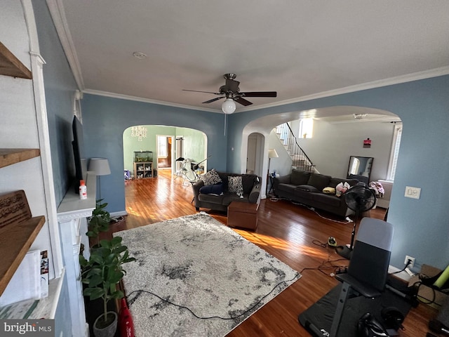 living room featuring wood-type flooring, ceiling fan, and crown molding