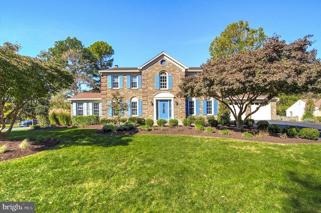 colonial house with a garage and a front yard