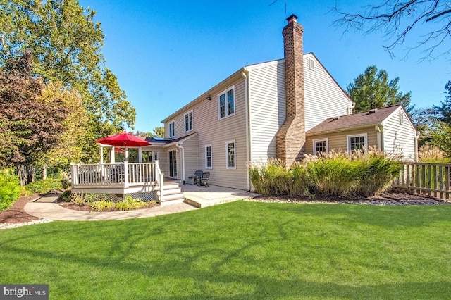 back of property with a lawn and a wooden deck