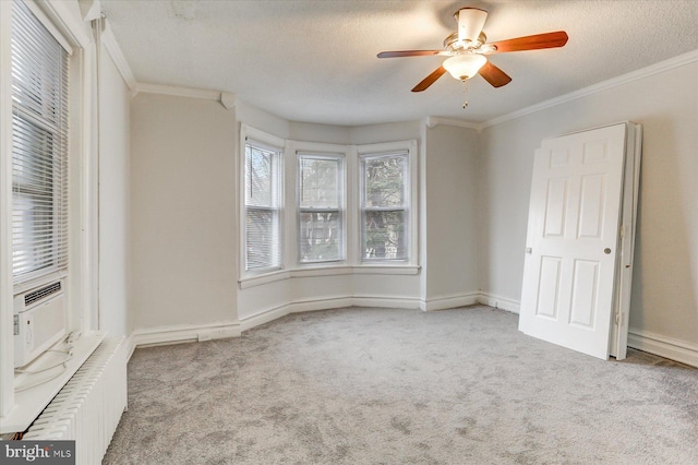 unfurnished bedroom with a textured ceiling, light colored carpet, ceiling fan, and ornamental molding