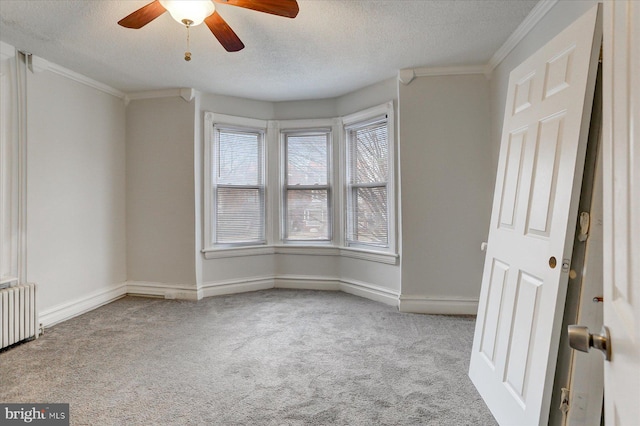 empty room featuring ceiling fan, light colored carpet, a textured ceiling, and radiator