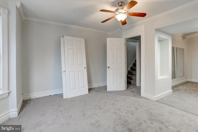 empty room featuring light carpet, ceiling fan, and ornamental molding