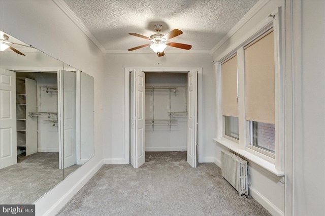 unfurnished bedroom with ceiling fan, light colored carpet, radiator heating unit, and ornamental molding