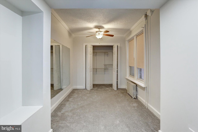 hall featuring crown molding, light colored carpet, a textured ceiling, and radiator