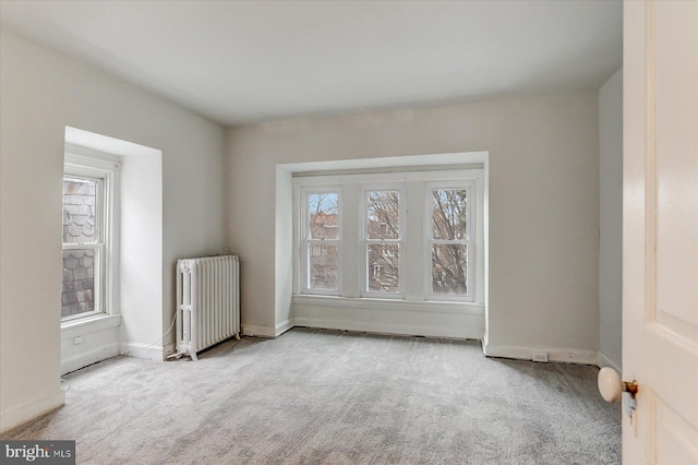 carpeted empty room with radiator and a wealth of natural light