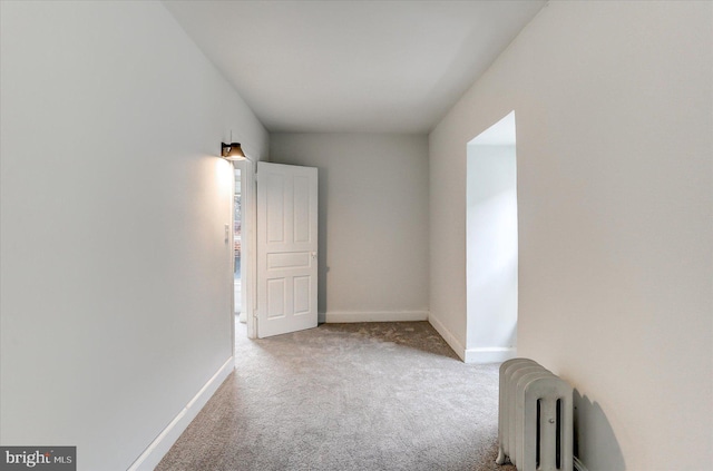 carpeted empty room with radiator