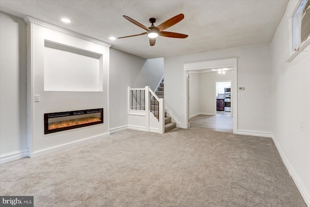 unfurnished living room featuring carpet flooring, a textured ceiling, and ceiling fan