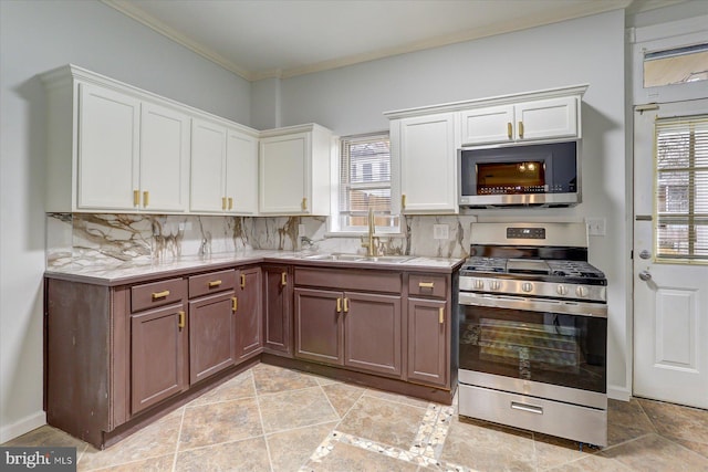 kitchen featuring appliances with stainless steel finishes, tasteful backsplash, white cabinetry, and sink