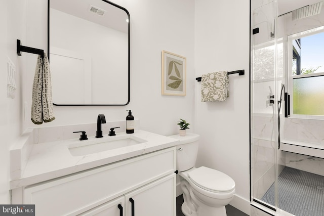 bathroom with vanity, toilet, and a shower with door